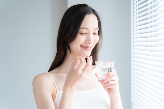 サプリメントを飲もうとしている女性